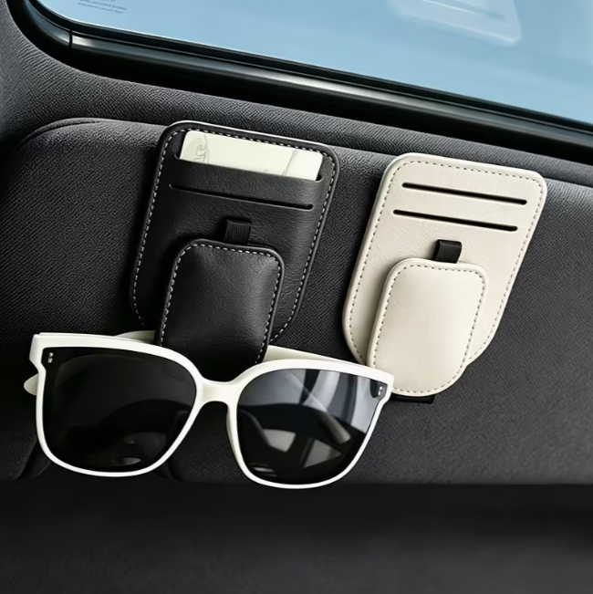 AutoPocket Premium holders in black and beige on a car sun visor, holding a card and white sunglasses